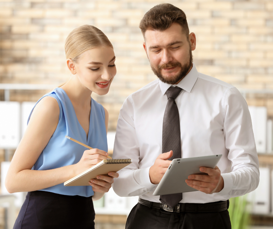 man showing woman features on iPad POS and woman taking notes