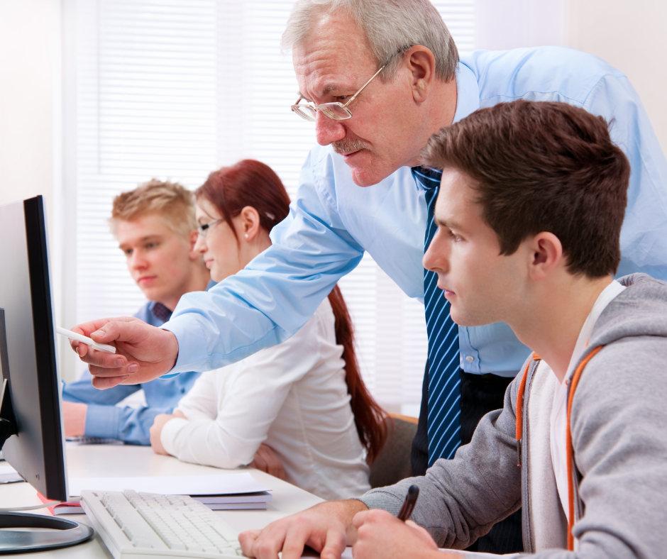 man point at computer screen showing younger man something