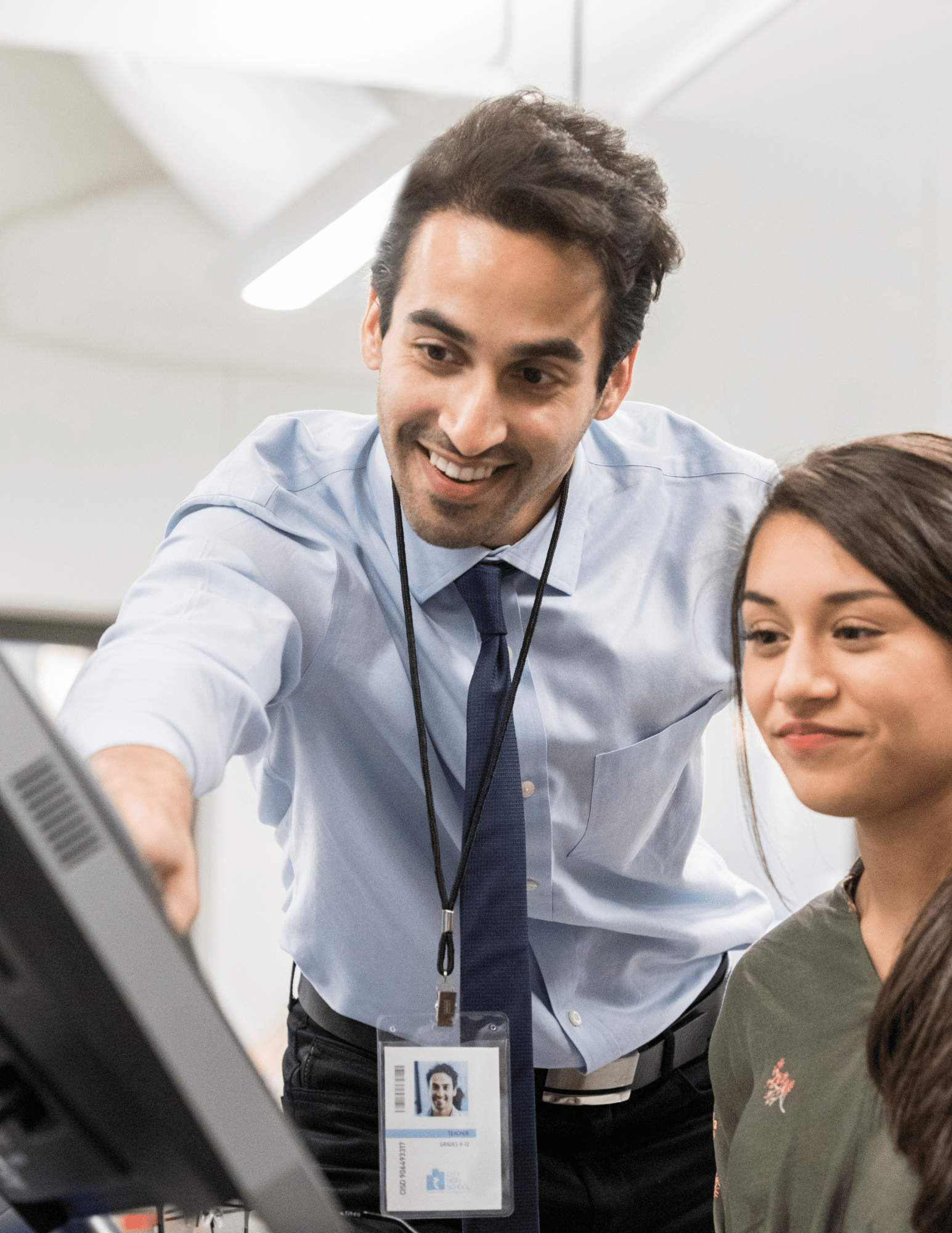 IT guy pointing at computer screen showing smiling woman something