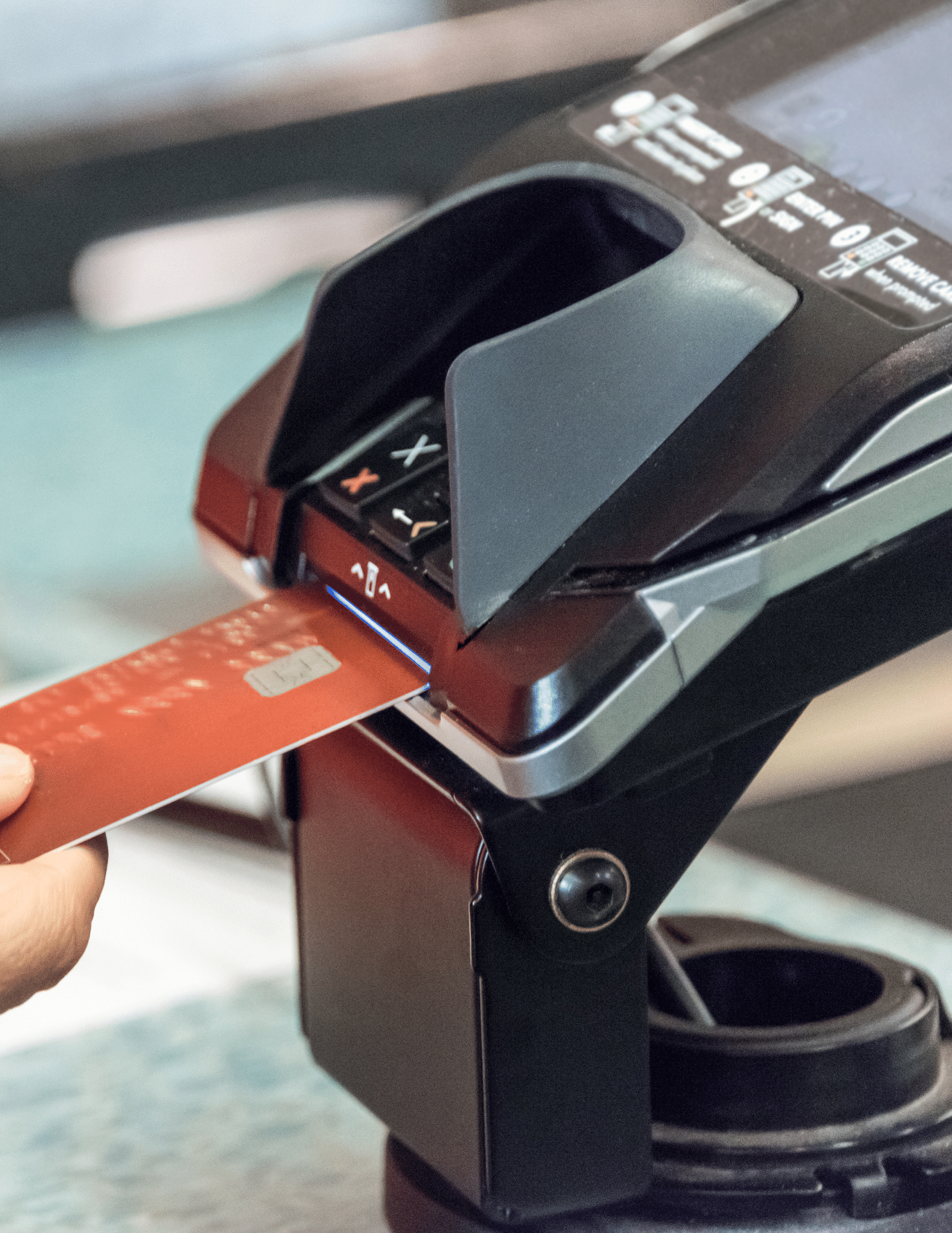 Close up of a debit transaction on payment processing machine, red card going into the bottom