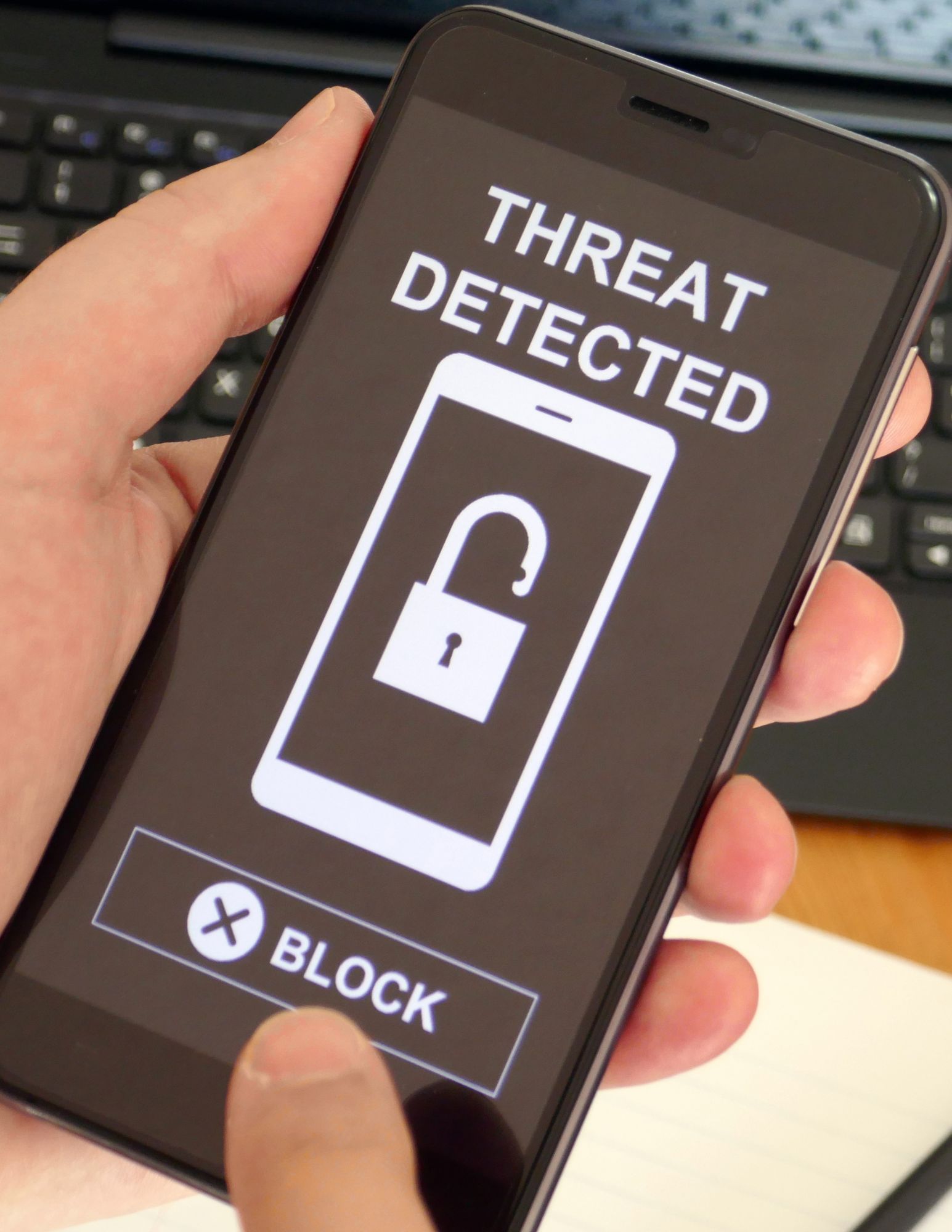 Close up of a phone screen with a lock and a message stating Threat Detected with an option to block